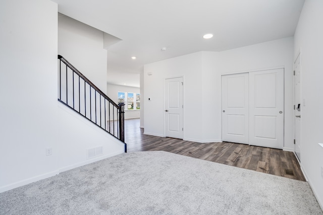 foyer with stairs, recessed lighting, visible vents, and wood finished floors