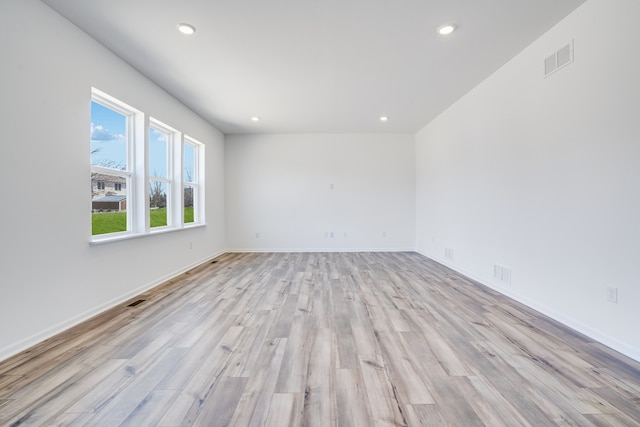 empty room with visible vents, recessed lighting, light wood-style flooring, and baseboards