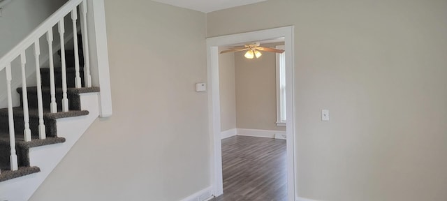corridor featuring baseboards, stairs, and wood finished floors