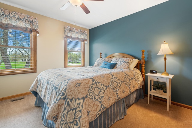carpeted bedroom with baseboards, ceiling fan, and visible vents