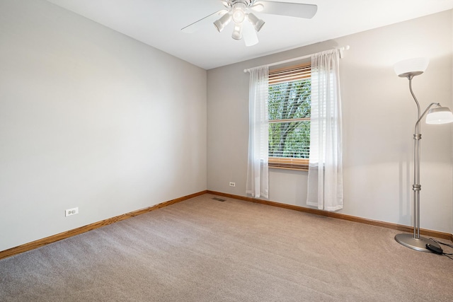 empty room with carpet floors, baseboards, and a ceiling fan