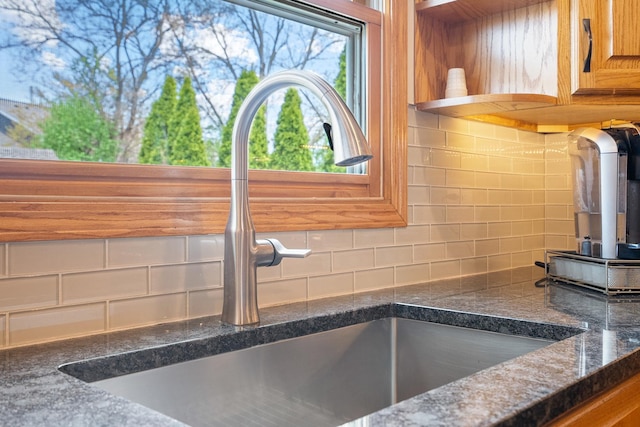 details featuring backsplash, brown cabinets, open shelves, and a sink