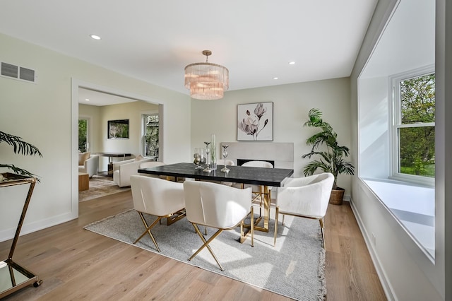 dining area with visible vents, a chandelier, wood finished floors, and a wealth of natural light