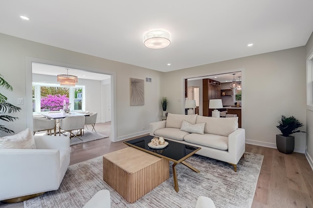 living room featuring light wood-style floors, baseboards, and recessed lighting