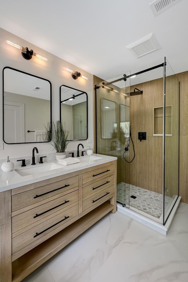 bathroom featuring visible vents, a sink, marble finish floor, and a stall shower
