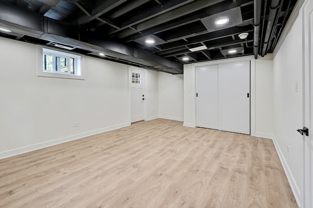 below grade area with baseboards, visible vents, and light wood finished floors