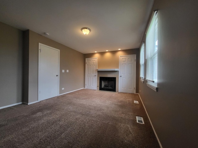 200 Rodenburg Rd, Roselle, IL 60172 - unfurnished living room featuring visible vents, carpet floors, baseboards, recessed lighting, and a fireplace with flush hearth