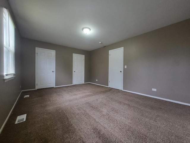 200 Rodenburg Rd, Roselle, IL 60172 - unfurnished bedroom with visible vents, baseboards, and dark carpet