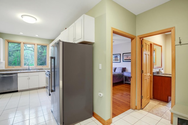 1730 Cambridge Ave, Flossmoor, IL 60422 - kitchen featuring white cabinets, stainless steel appliances, light tile patterned flooring, and a sink