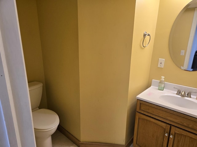 half bathroom with toilet, tile patterned flooring, and vanity