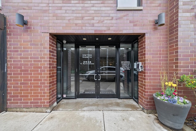 property entrance featuring a carport, french doors, and brick siding