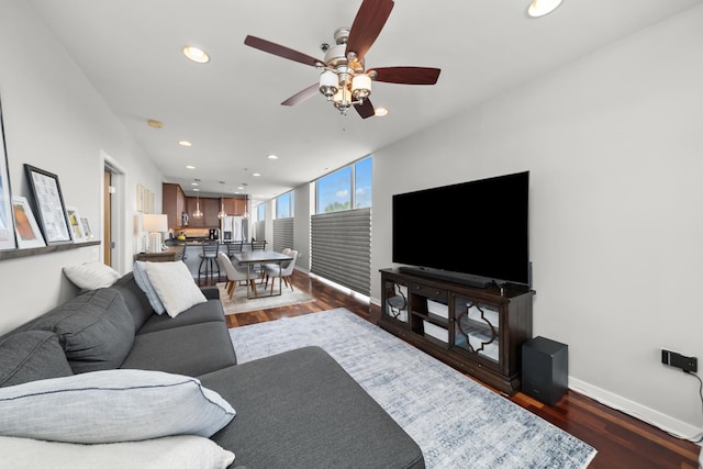 living area with baseboards, dark wood-type flooring, a ceiling fan, and recessed lighting