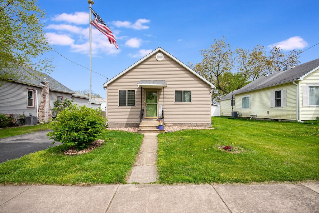 314 N Cedar St, Gardner, IL 60424 - bungalow-style home with central air condition unit, entry steps, and a front yard