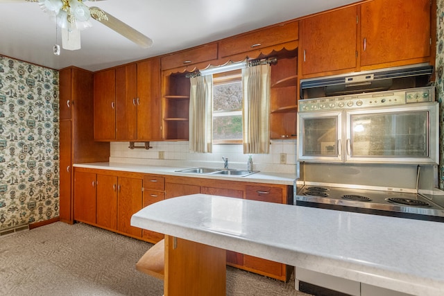 kitchen featuring a sink, light countertops, open shelves, and wallpapered walls