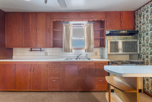 kitchen featuring light countertops, open shelves, a sink, and wallpapered walls