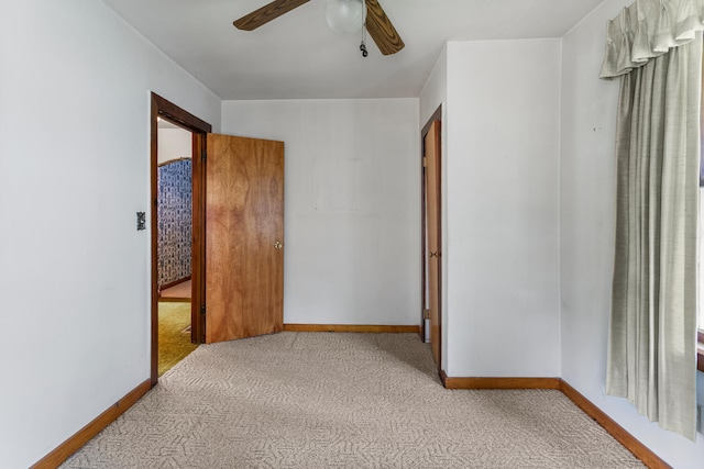 unfurnished bedroom with carpet floors, baseboards, and ceiling fan