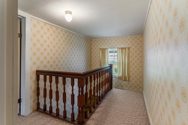 corridor featuring crown molding, wallpapered walls, an upstairs landing, and carpet floors