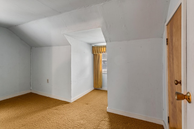 additional living space featuring baseboards, light colored carpet, and lofted ceiling