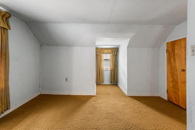 bonus room with baseboards, vaulted ceiling, and light carpet