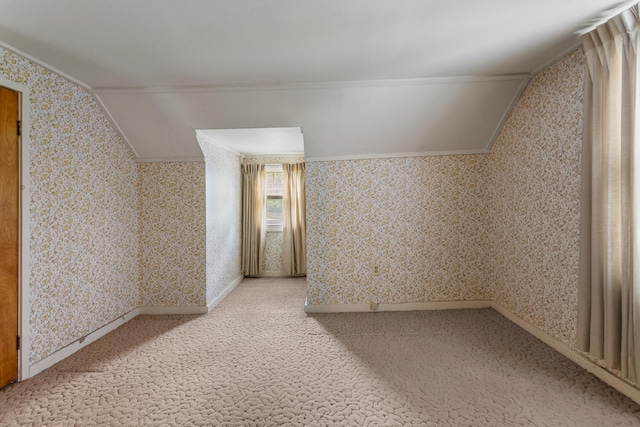 bonus room with baseboards, light carpet, and wallpapered walls
