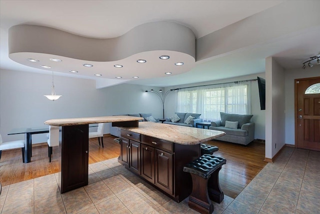 33 Half Day Rd, Lincolnshire, IL 60069 - kitchen with light tile patterned floors, recessed lighting, dark brown cabinetry, hanging light fixtures, and a center island