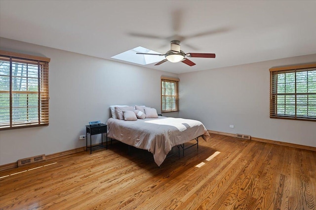 33 Half Day Rd, Lincolnshire, IL 60069 - bedroom featuring a skylight, light wood-style flooring, ceiling fan, and baseboards