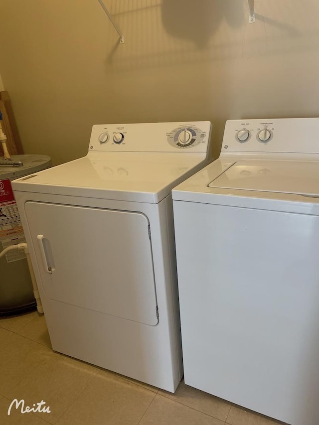 washroom with water heater, laundry area, light tile patterned floors, and independent washer and dryer