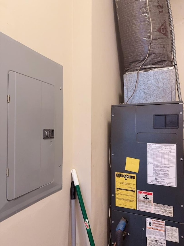 utility room featuring heating unit and electric panel