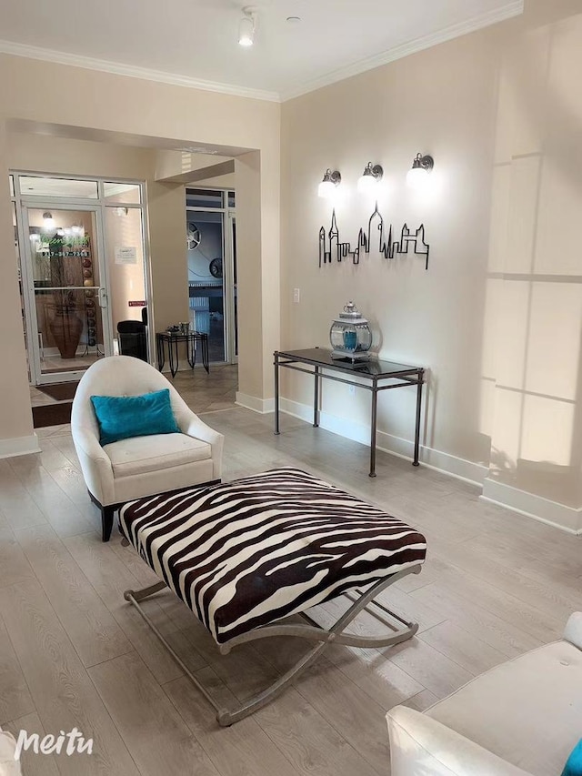living area with ornamental molding, baseboards, and wood finished floors