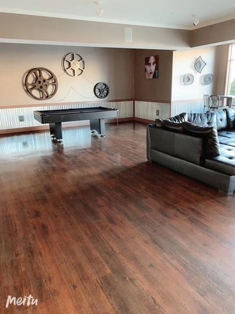 living room with crown molding, pool table, and wood finished floors