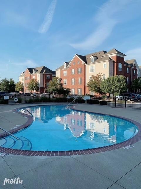 pool featuring fence and a residential view