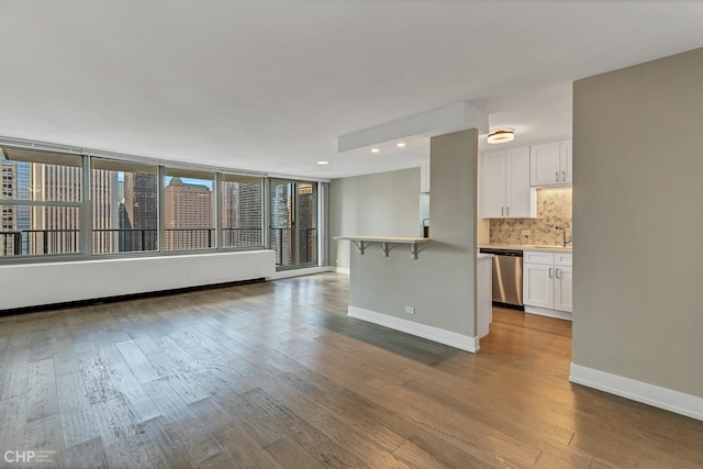 400 E Randolph St Unit 3428, Chicago, IL 60601 - unfurnished living room featuring baseboards, recessed lighting, dark wood-style flooring, and a sink