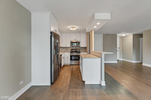 400 E Randolph St Unit 3428, Chicago, IL 60601 - kitchen with a peninsula, stainless steel appliances, light countertops, decorative backsplash, and white cabinets