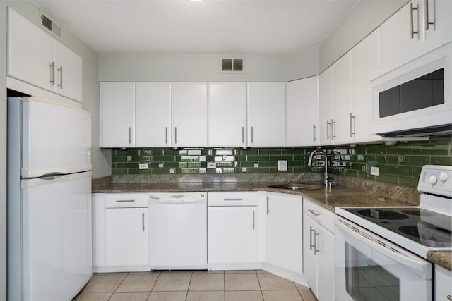kitchen featuring white appliances, white cabinetry, visible vents, and a sink