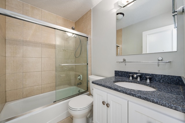 full bath featuring vanity, combined bath / shower with glass door, toilet, and a textured ceiling