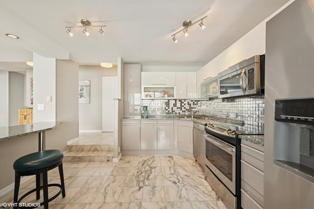 5733 N Sheridan Rd Unit 29D, Chicago, IL 60660 - kitchen with appliances with stainless steel finishes, stone counters, light marble finish floors, white cabinets, and backsplash