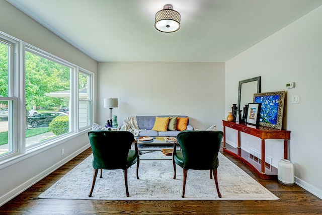 living room with baseboards and dark wood-type flooring