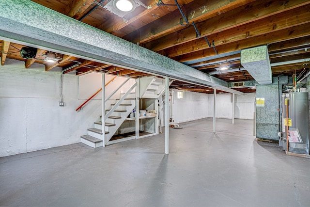 unfinished basement featuring stairs, heating unit, and gas water heater