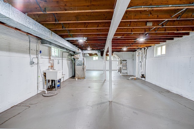 basement featuring a sink and heating unit