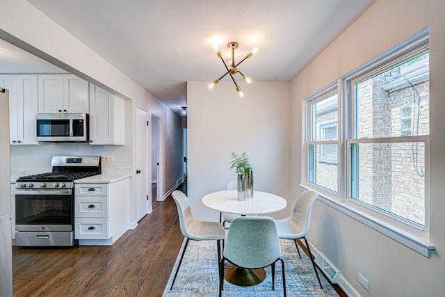 dining area with baseboards, visible vents, dark wood finished floors, and a notable chandelier