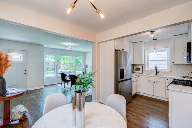 kitchen with a sink, white cabinets, stainless steel appliances, and a wealth of natural light