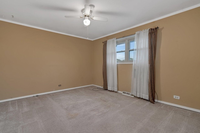 empty room with a ceiling fan, visible vents, baseboards, light colored carpet, and ornamental molding