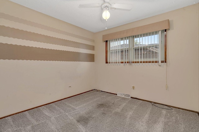 carpeted spare room featuring baseboards, visible vents, and a ceiling fan