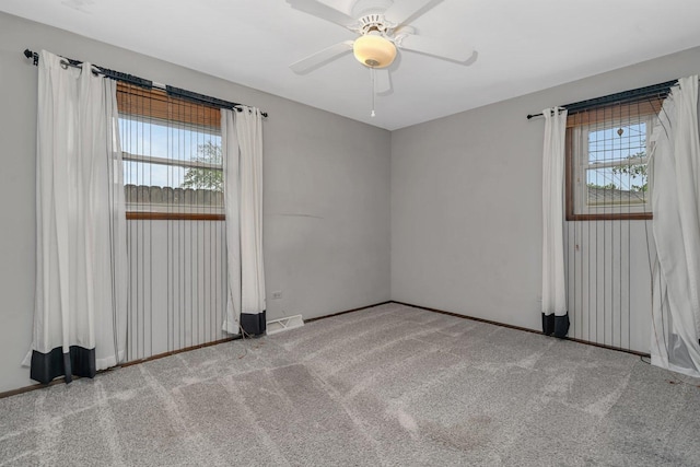 spare room with carpet, baseboards, and ceiling fan