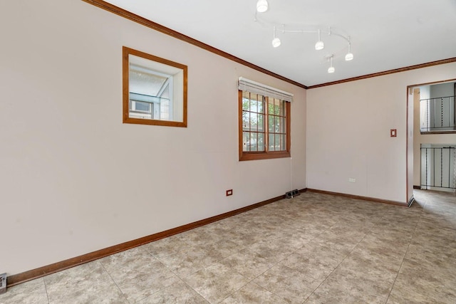 empty room featuring baseboards and crown molding
