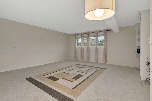 unfurnished room featuring beamed ceiling and carpet floors