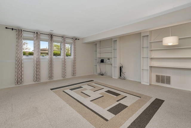 unfurnished living room with carpet flooring and visible vents