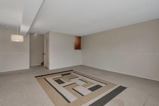 unfurnished room with carpet flooring and wooden walls