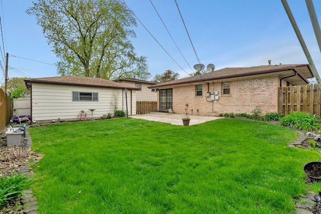back of house with a yard, a patio, brick siding, and fence