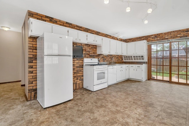 kitchen with dark countertops, white cabinetry, a sink, and white appliances